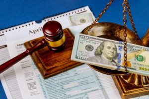Hundred US dollar bills on a table scales of justice, gavel IRS form. 1040 U.S tax forms April 15 of the deadline time tax season calendar